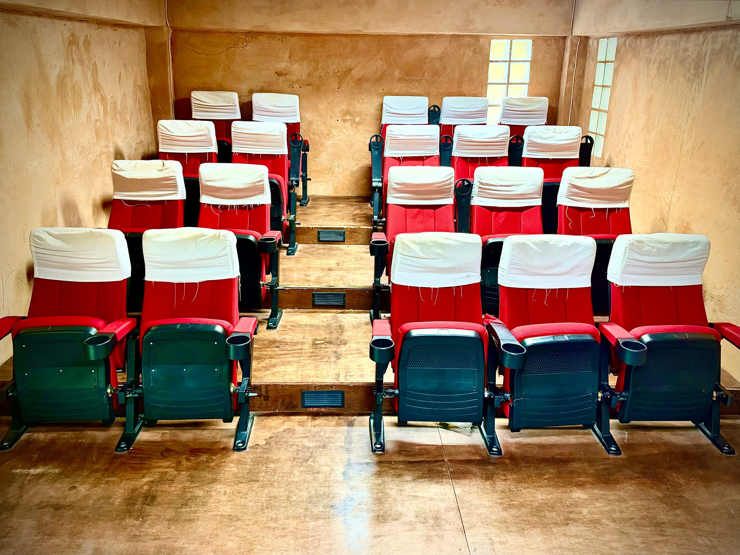 Rows of red cinema-style seating in the straw bale auditorium